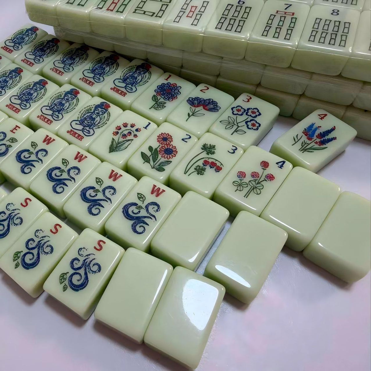 Florence Mint American mahjong tile set with jokers, flowers, winds and blank tiles on a table
