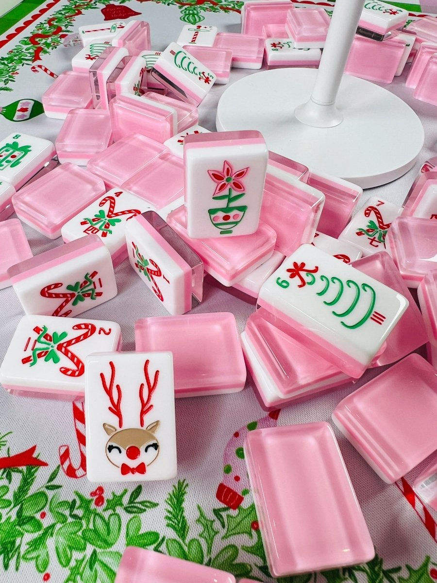 Pink Reindeer acrylic American mahjong tiles piled on holiday tablecloth — blush pink lifestyle layout, Mahjong Loft