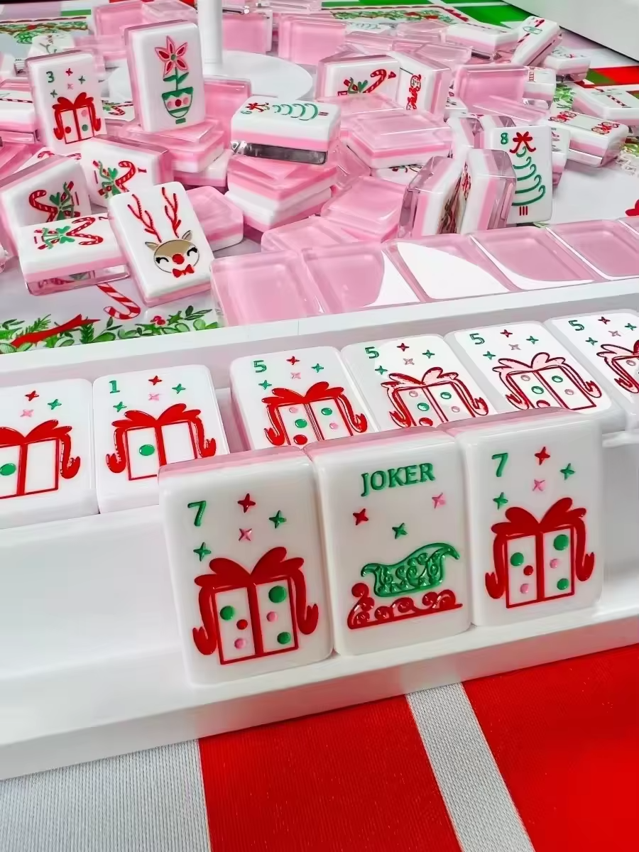 Pink Reindeer acrylic American mahjong joker tiles in rack close-up — sleigh and gift face detail, Mahjong Loft