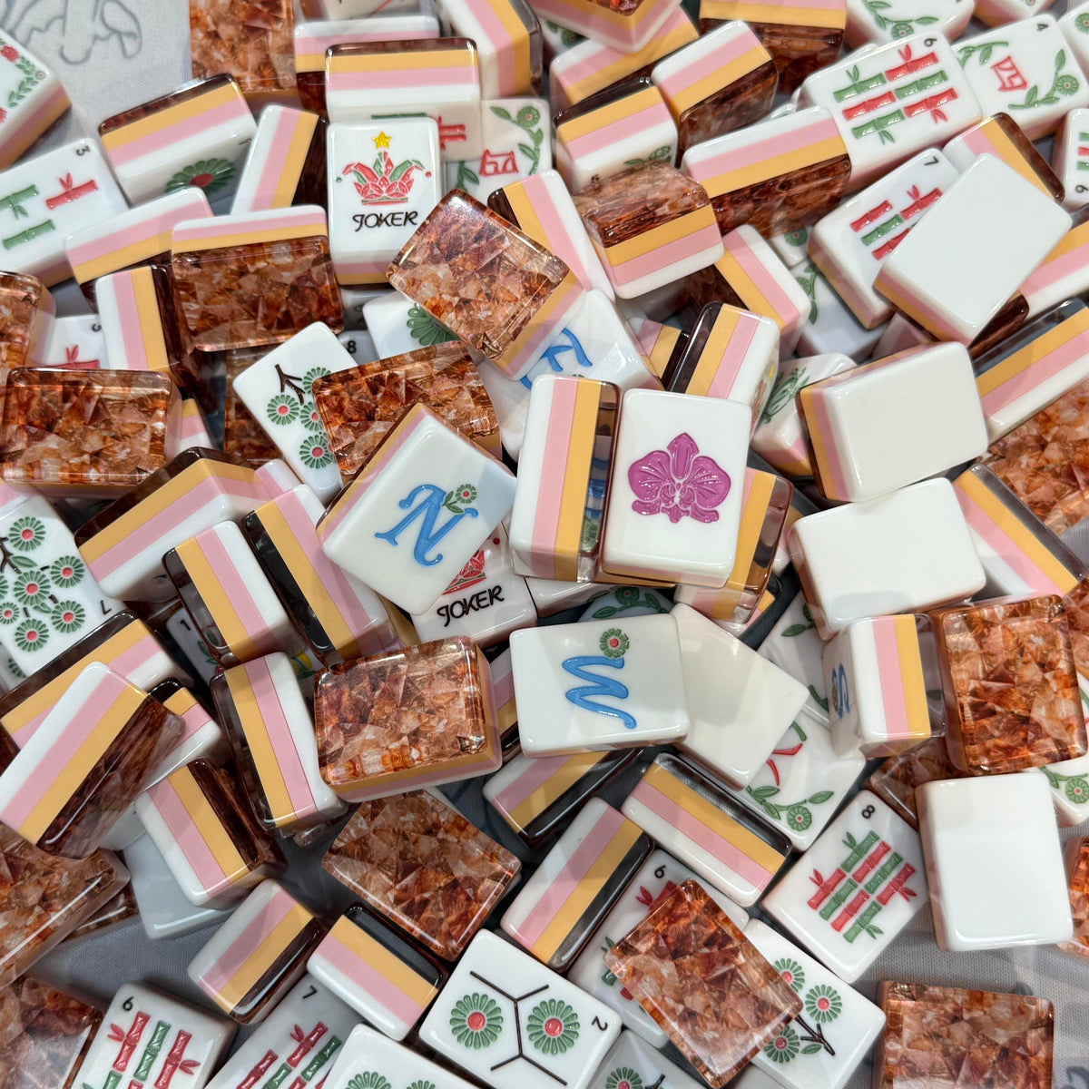 Amber Vine acrylic American mahjong scattered lifestyle pile with joker and winds — jester hat jokers blue N W florals copper flakes, Mahjong Loft