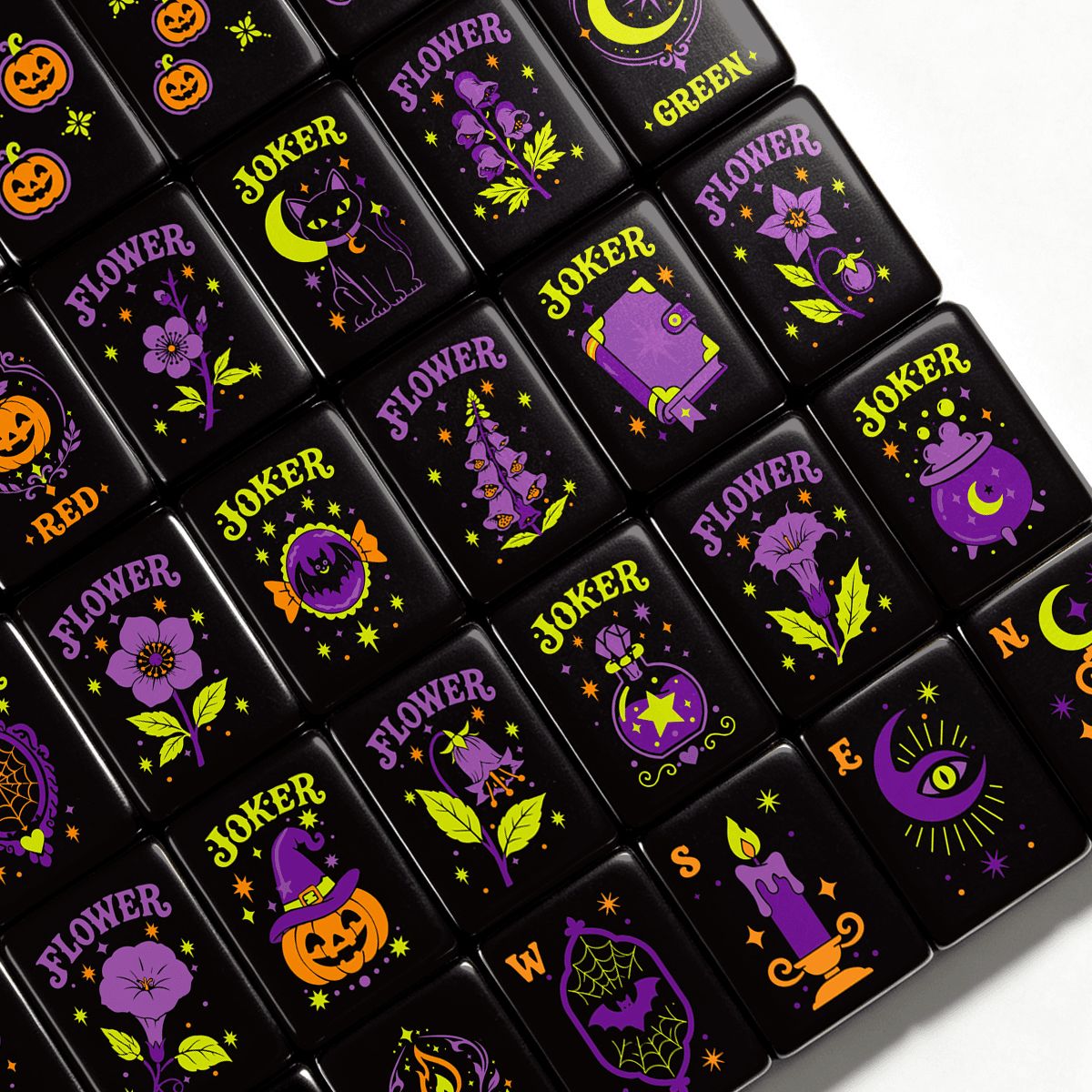 Pumpkin Hex Halloween mahjong tiles close-up with purple witchy flowers, jack-o'-lanterns, black cats, cauldrons, moons and stars on black acrylic tiles