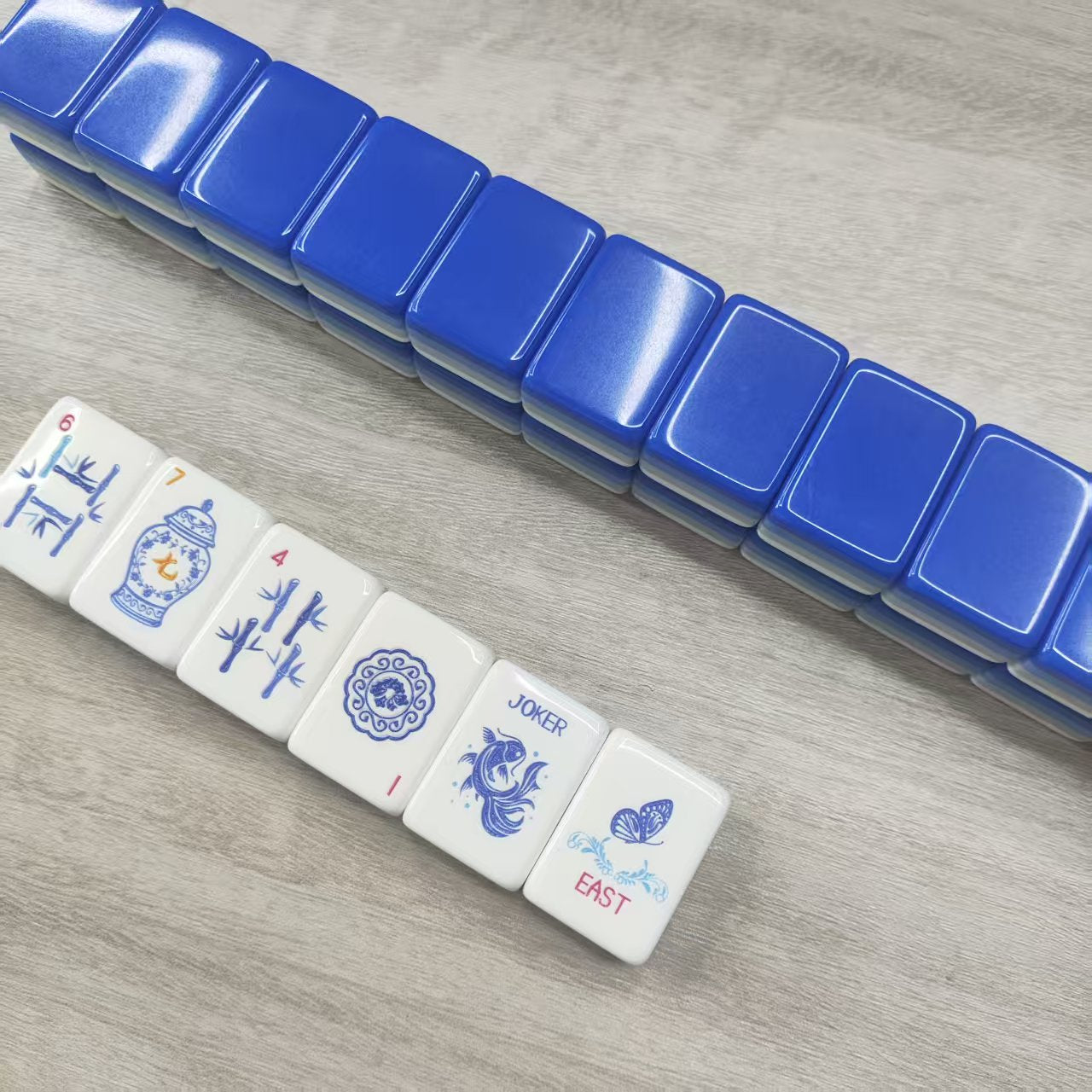 Porcelain Coast blue-and-white porcelain acrylic American mahjong tile set tiles arranged on a clear pusher