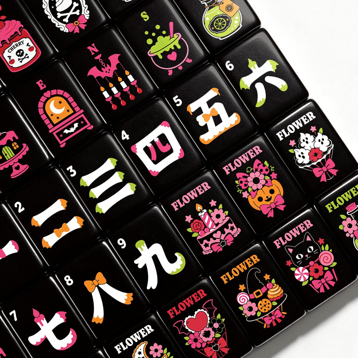Angled close-up of Gothic Dessert Halloween mahjong tiles showing pink potion bottles, bones, Chinese numeral cracks, and pastel Flower tiles featuring pumpkins, black cats, and bows on black acrylic
